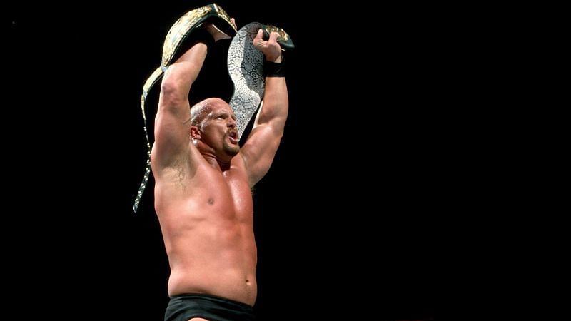 Stone Cold holds the WWE and Smoking Skull Championship belts aloft