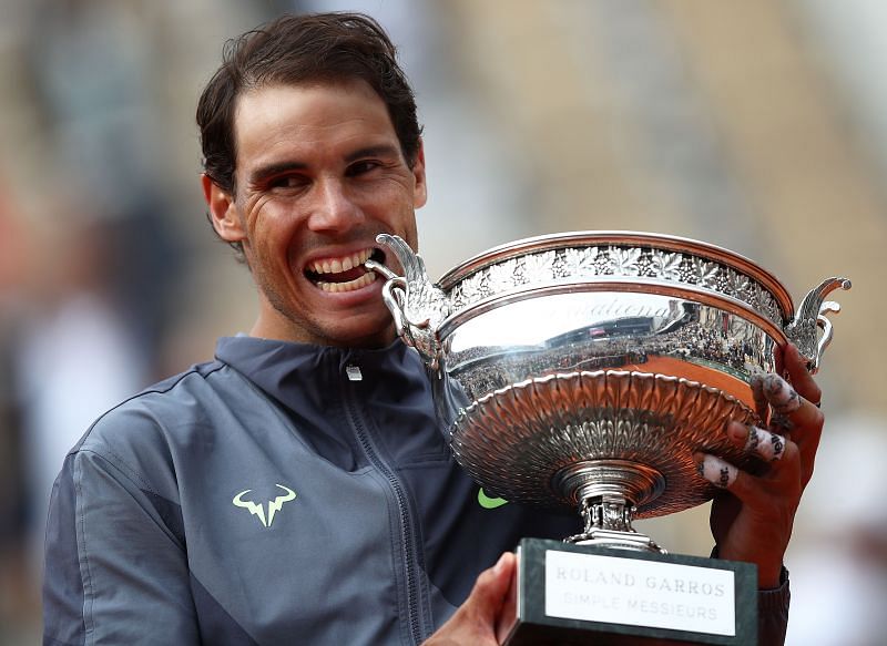 Rafael Nadal takes a bite of the 2019 Roland Garros trophy.