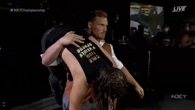 Ridge Holland carries Adam Cole to the ringside area where he dumps him at NXT TakeOver 31 after the main event between Finn Balor and Kyle O&#039;Reilly