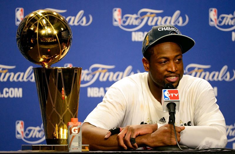 Dwyane Wade #3 of the Miami Heat smiles next to the Larry O&#039;Brien Finals Championship trophy.