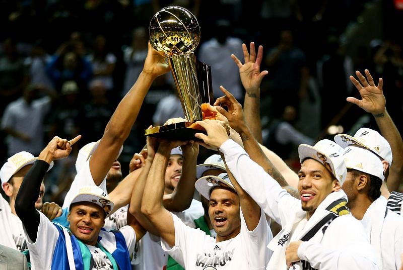 The San Antonio Spurs celebrate with the Larry O&#039;Brien trophy after defeating the Miami Heat to win the 2014 NBA Finals.