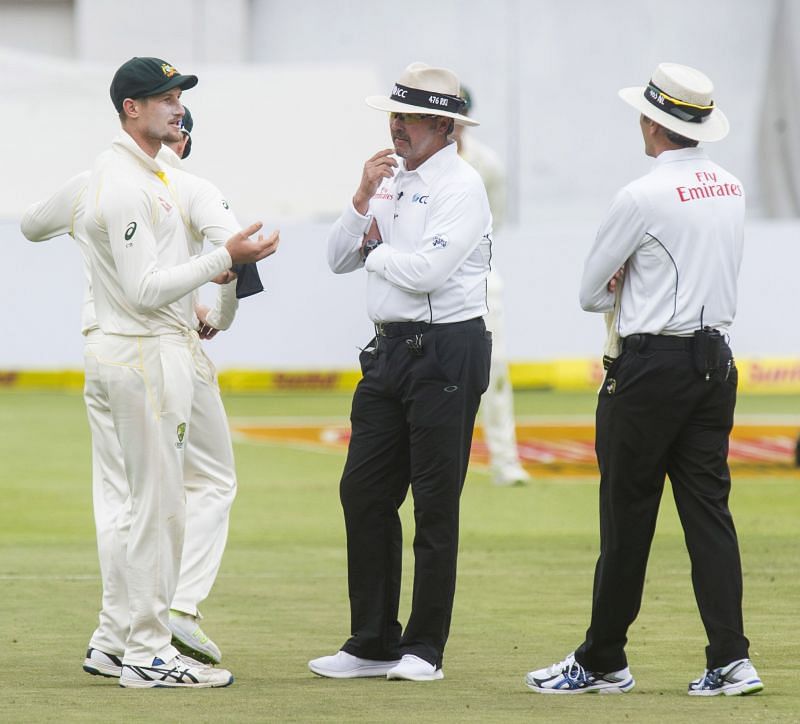 Cameron Bancroft being questioned by umpires Nigel Llong and Richard Illingworth after the cameras caught him in the act