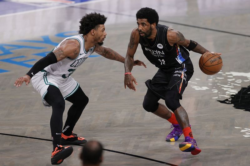 Kyrie Irving (#11) dribbles past Marcus Smart (#36).