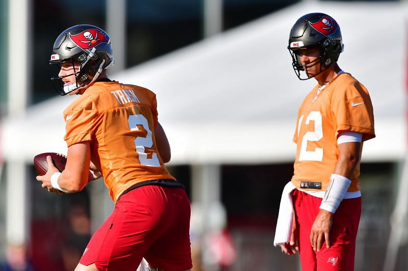 Tom Brady #12 looks on as Kyle Trask #2 hikes the ball in Tampa Bay Buccaneers Training Camp