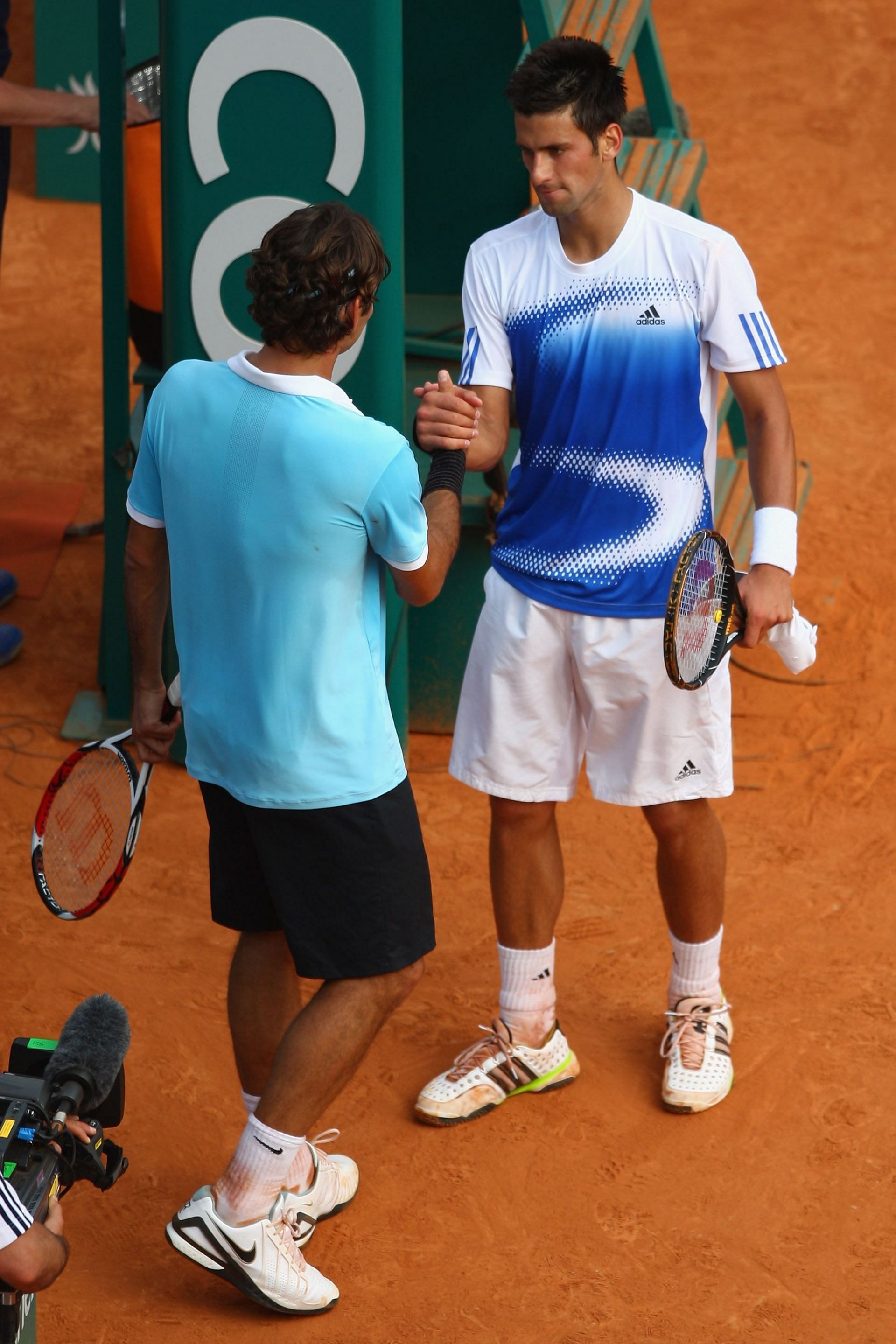 Roger Federer and Novak Djokovic shake hands after the latter retired
