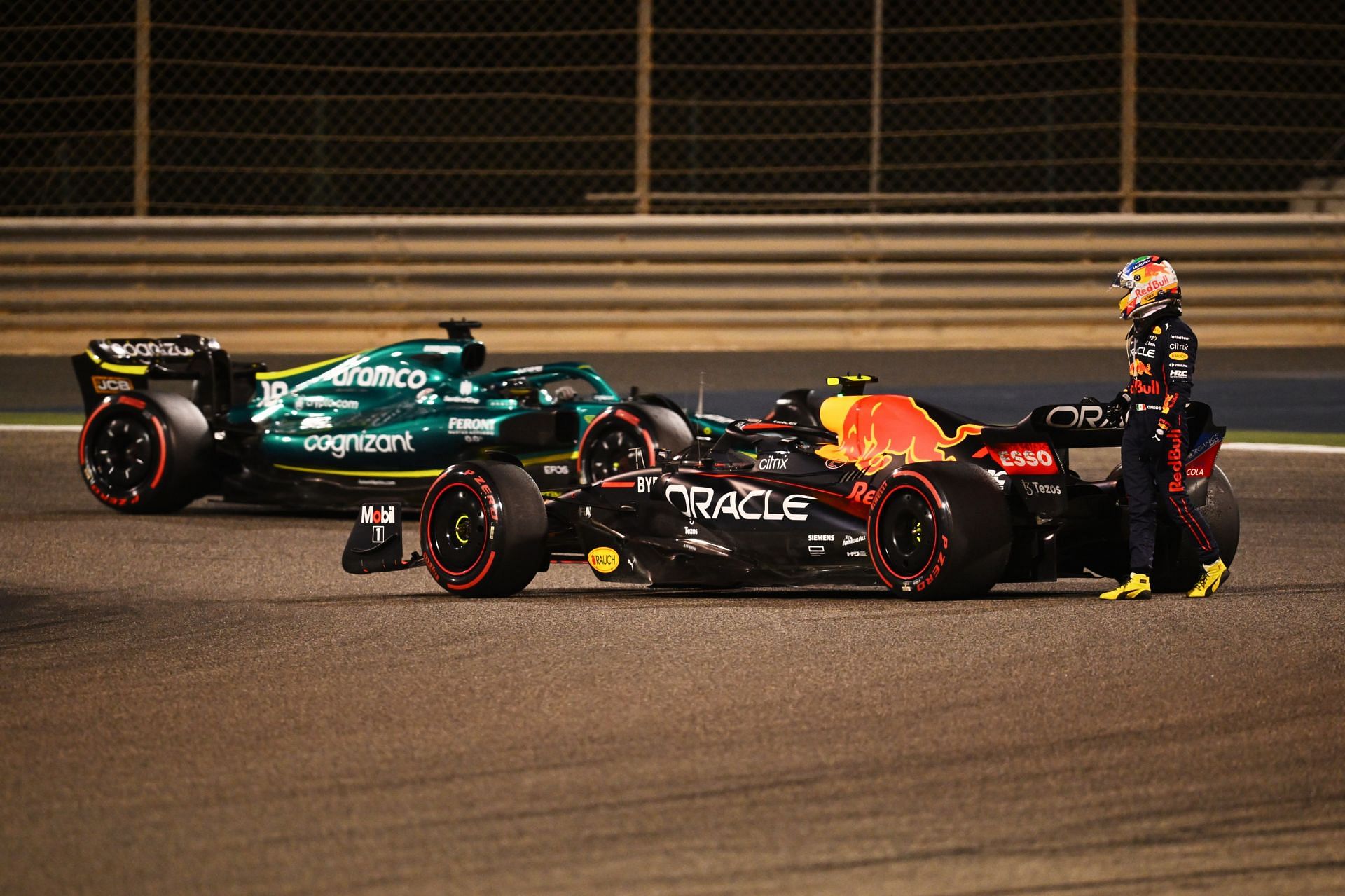 Sergio Perez inspecting his Red Bull after engine failure on the last lap of the Bahrain Grand Prix 2022. (Image via Clive Mason/Getty Images)