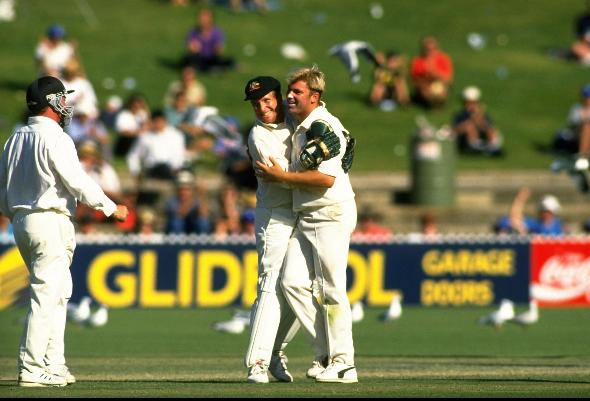 Ian Healy congratulates Shane Warne on his 100th Test wicket during a Test against South Africa at the Adelaide Oval. Pic: Getty Images