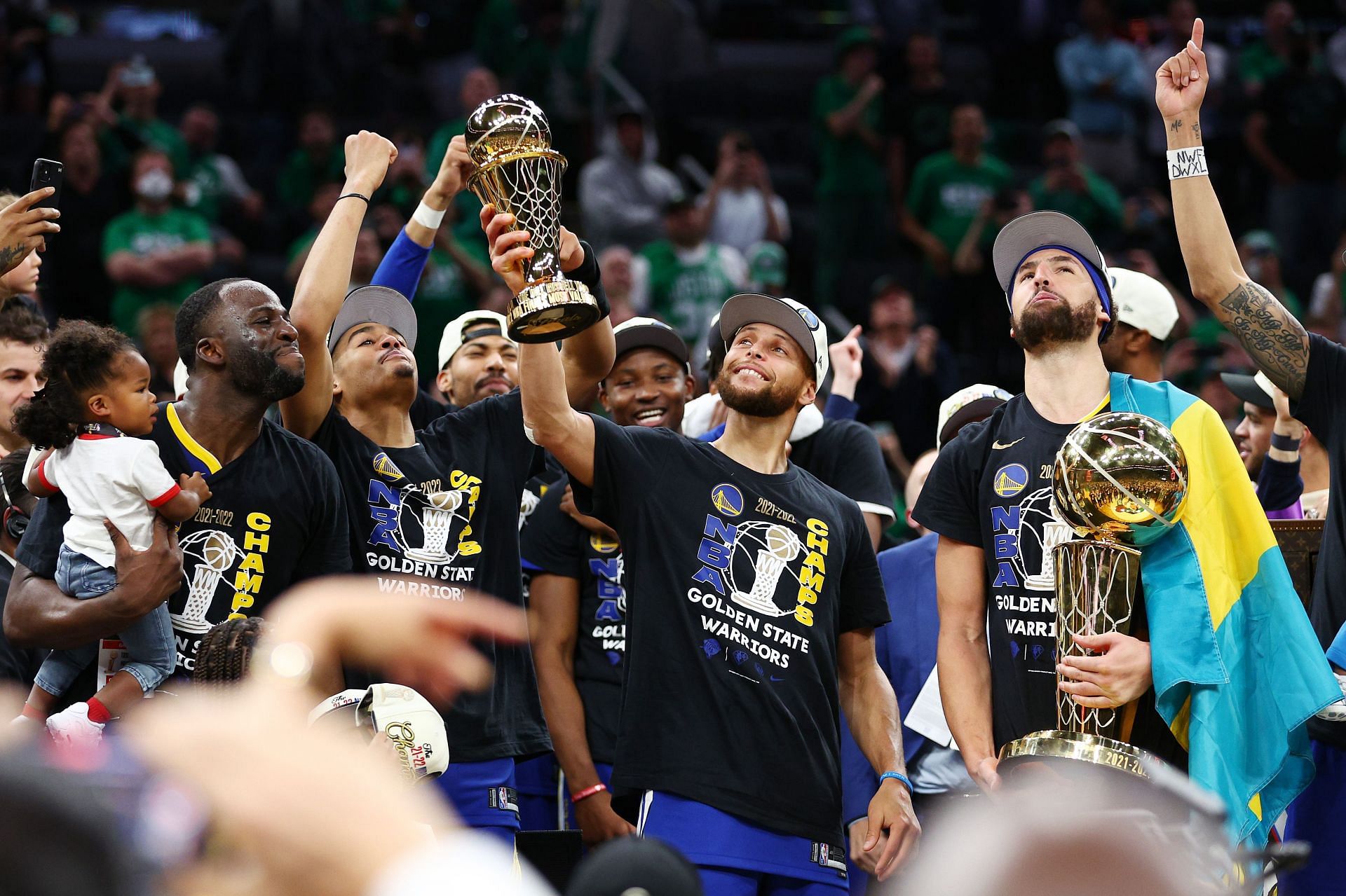 Steph Curry of the Golden State Warriors raises the Finals MVP trophy after winning the 2022 NBA Finals