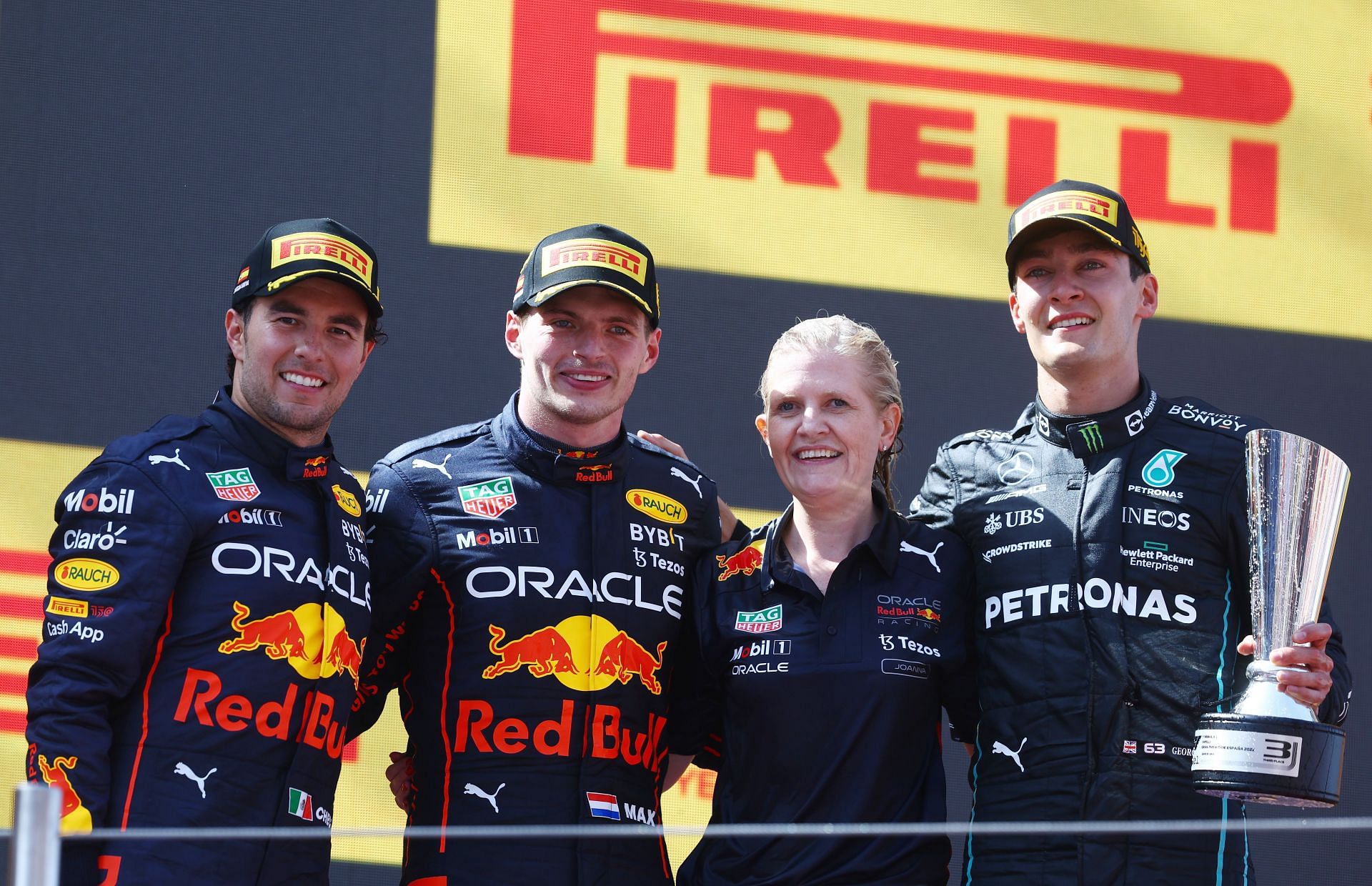 (L to R) Sergio Perez, Max Verstappen, Joanna Fleet, and George Russell celebrate on the podium during the F1 Grand Prix of Spain at Circuit de Barcelona-Catalunya on May 22, 2022, in Barcelona, Spain (Photo by Mark Thompson/Getty Images)