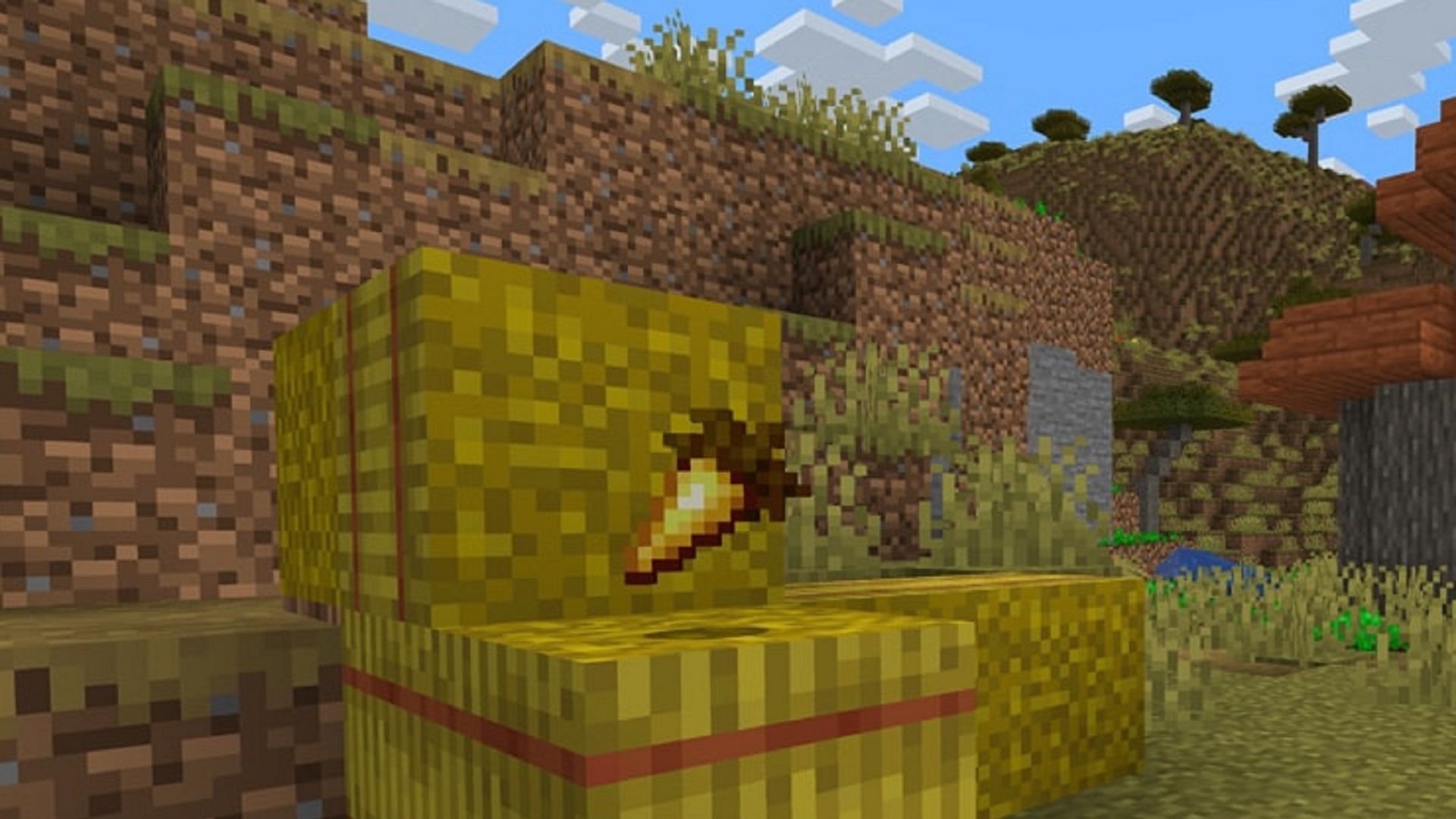 A golden carrot rests on a hay bale in Minecraft (Image via Minecraft.net)