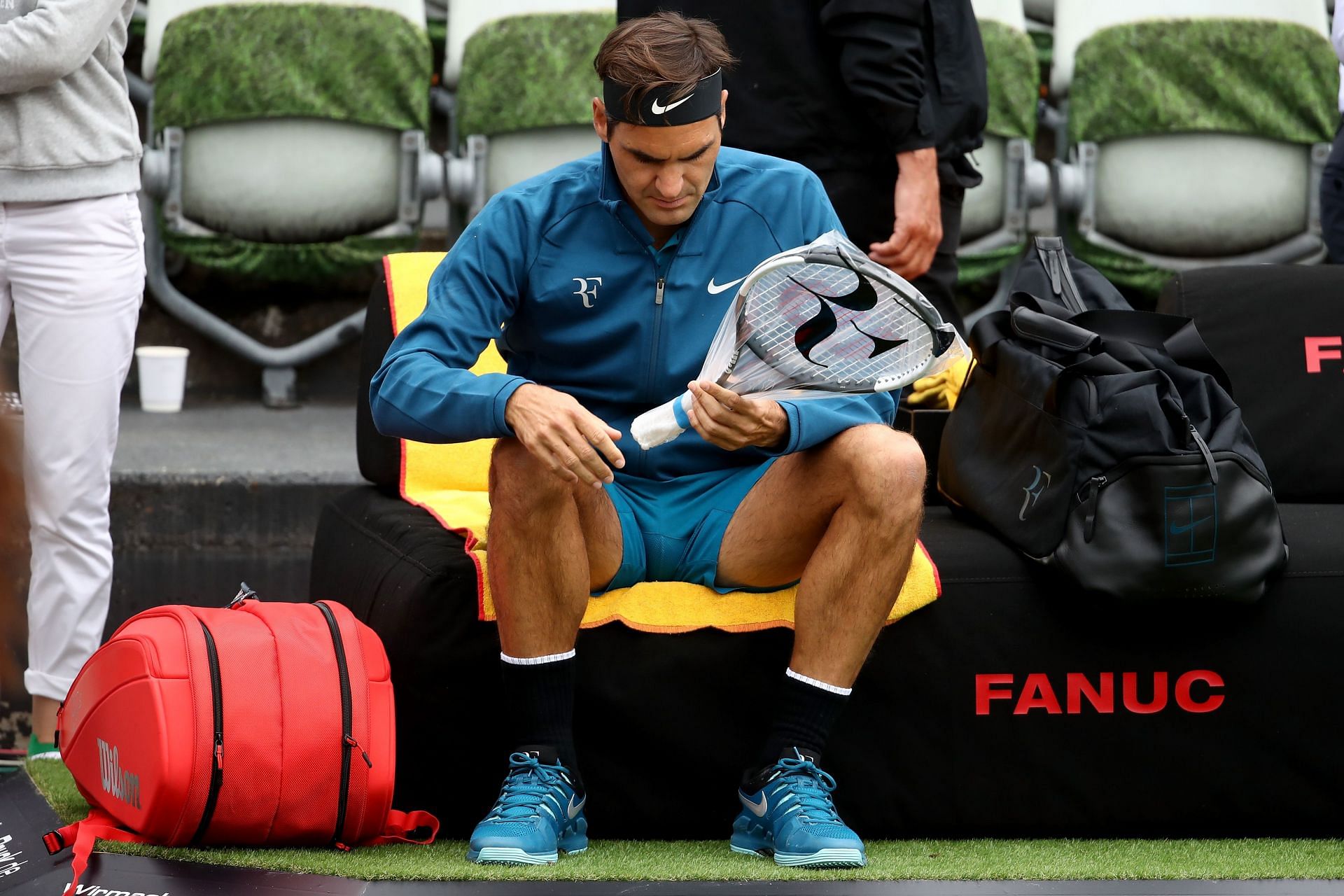Roger Federer with a Wilson racquet in Nike jacket with the RF logo