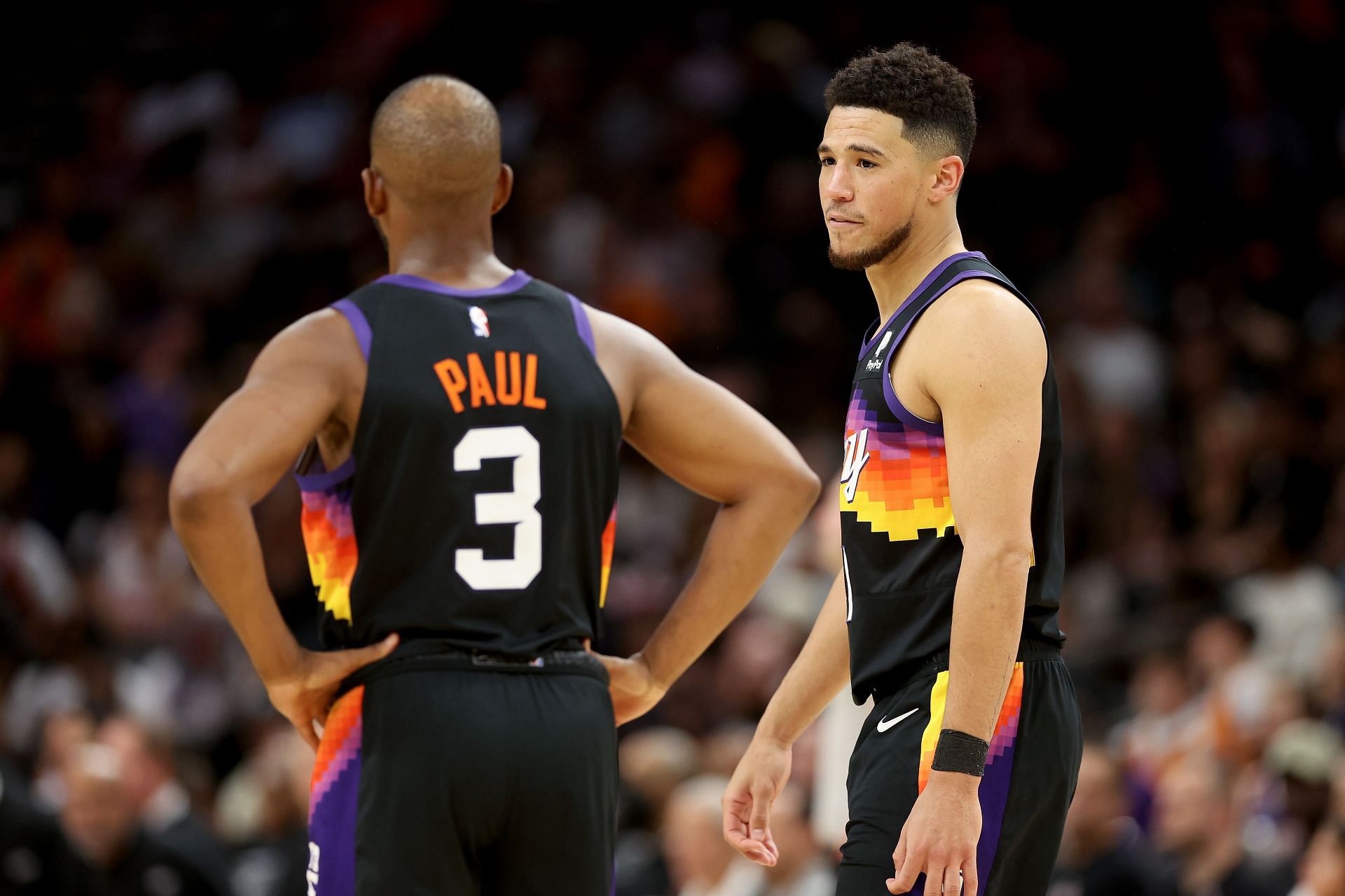 Chris Paul discusses the game with Devin Booker.