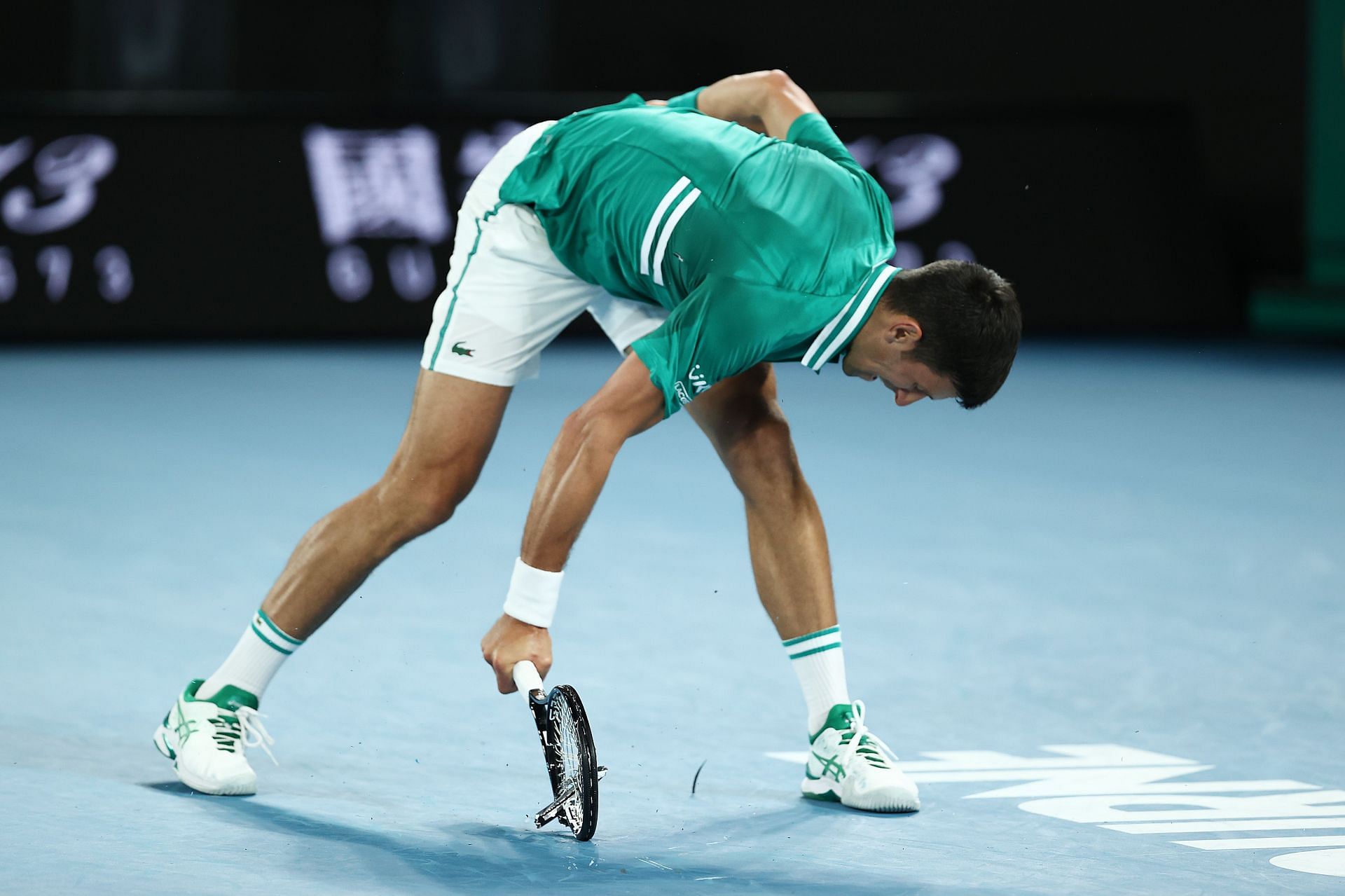 Novak Djokovic smashes his racquet in frustration during his 2021 Australian Open quarterfinal match against Alexander Zverev.