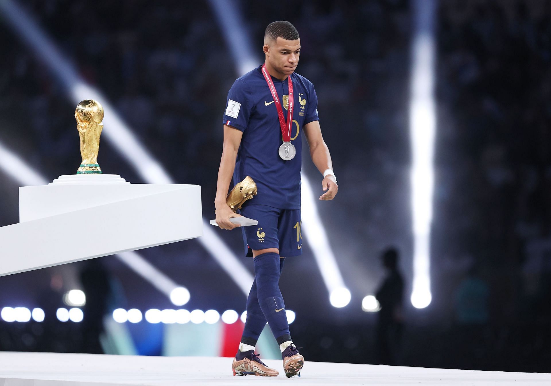 Pemain Timnas Prancis, Kylian Mbappe tampak gontai melangkah di podium Final Piala Dunia 2022 di Lusail Stadium, Qatar, Minggu (18/12/2022). Meski meyebet trofi golden boots awards dengan torehan 7 gol di edisi Piala Dunia kali ini, Mbappe tak mampu mengantar Prancis mengalahkan Argentina di final.