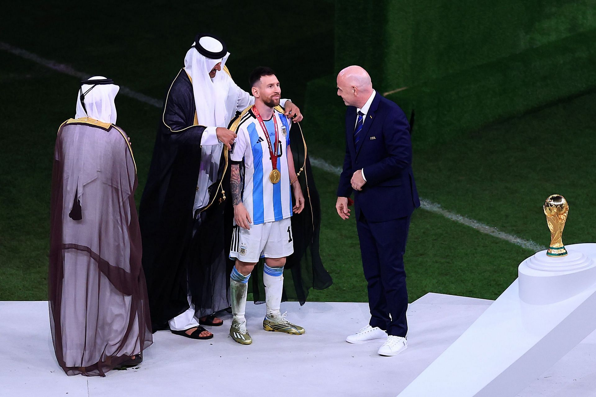 Penguasa Qatar, Tamim bin Hamed Al Thani menyandangkan Lionel Messi dengan jubah tradisional Arab 'Bisht' sebelum dia mengangkat trofi Piala Dunia.