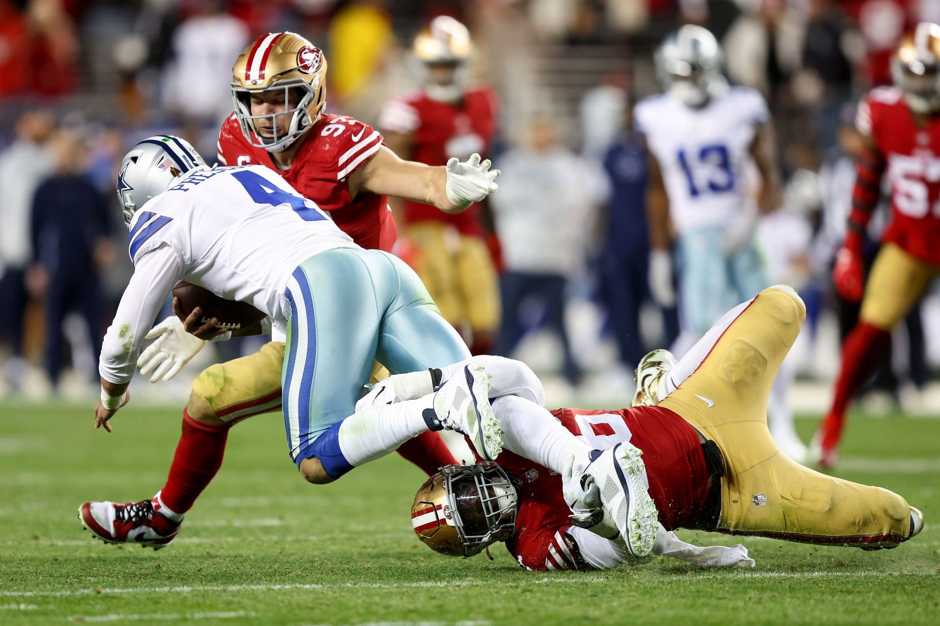 Nick Bosa and Samson Ebukam of the San Francisco 49ers tackle Dak Prescott of the Dallas Cowboys during the fourth quarter in the NFC Divisional Playoff game