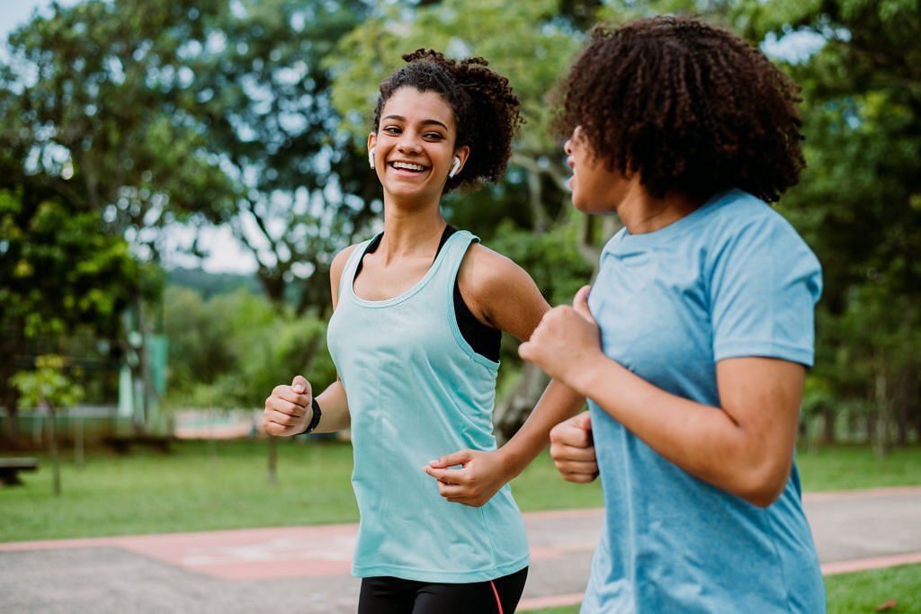 Two teenage girl friends running, exercising(Image via Getty Images)