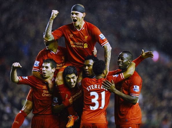 Martin Skrtel of Liverpool jumps on the shoulders of Daniel Sturridge (2nd R) after the third goal during during the Barclays Premier League match between Liverpool and Everton at Anfield on January 28, 2014 in Liverpool, England.  