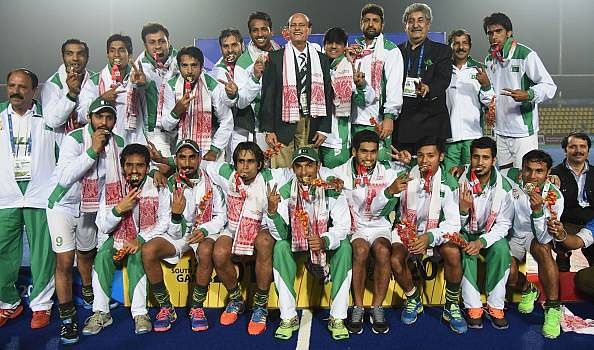 The Pakistan players pose after winning hockey gold