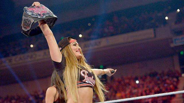 Nikki Bella in the ring holding up the Divas Championship